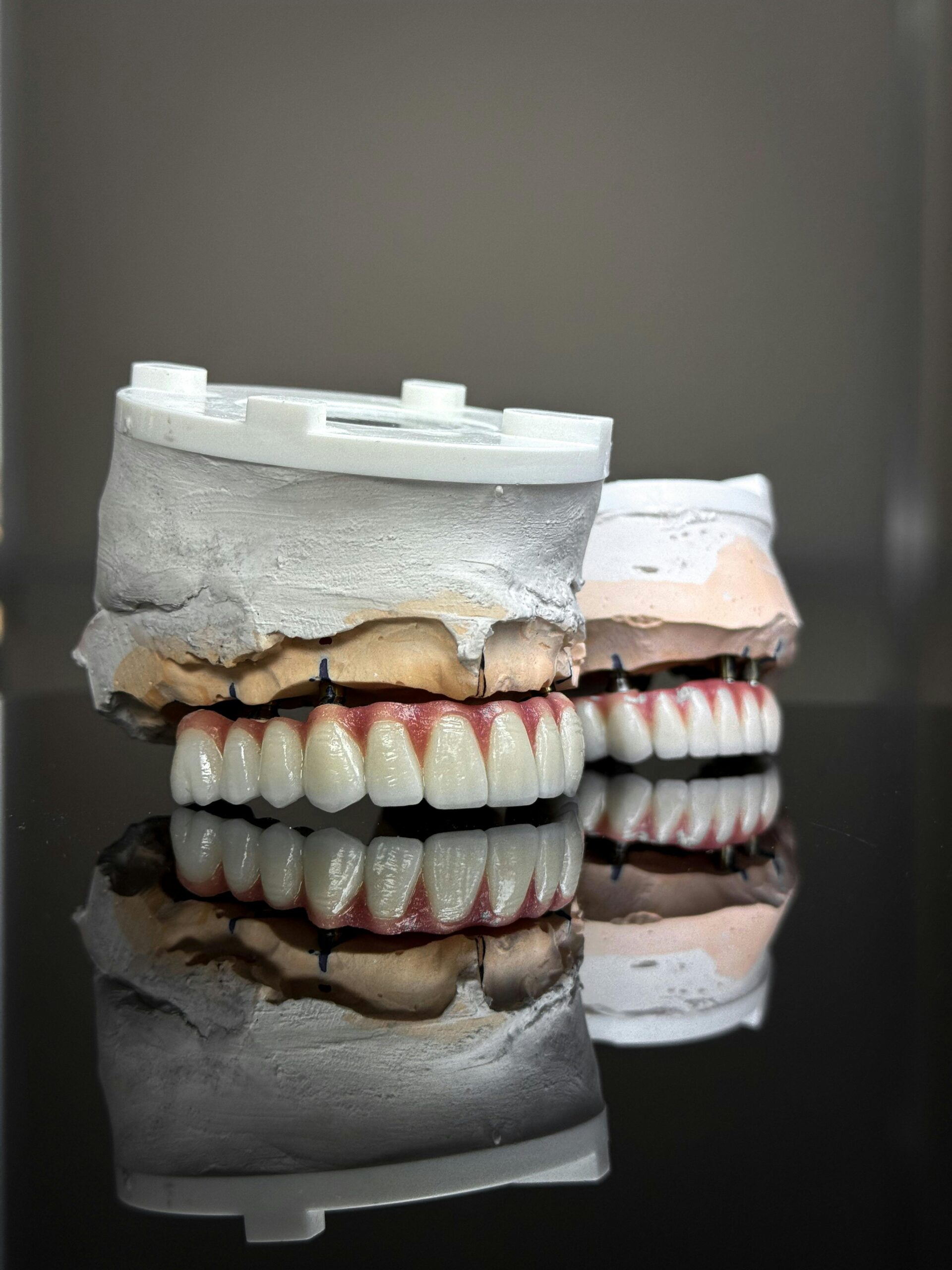 Realistic dental models showcasing artificial teeth with perfect reflections.