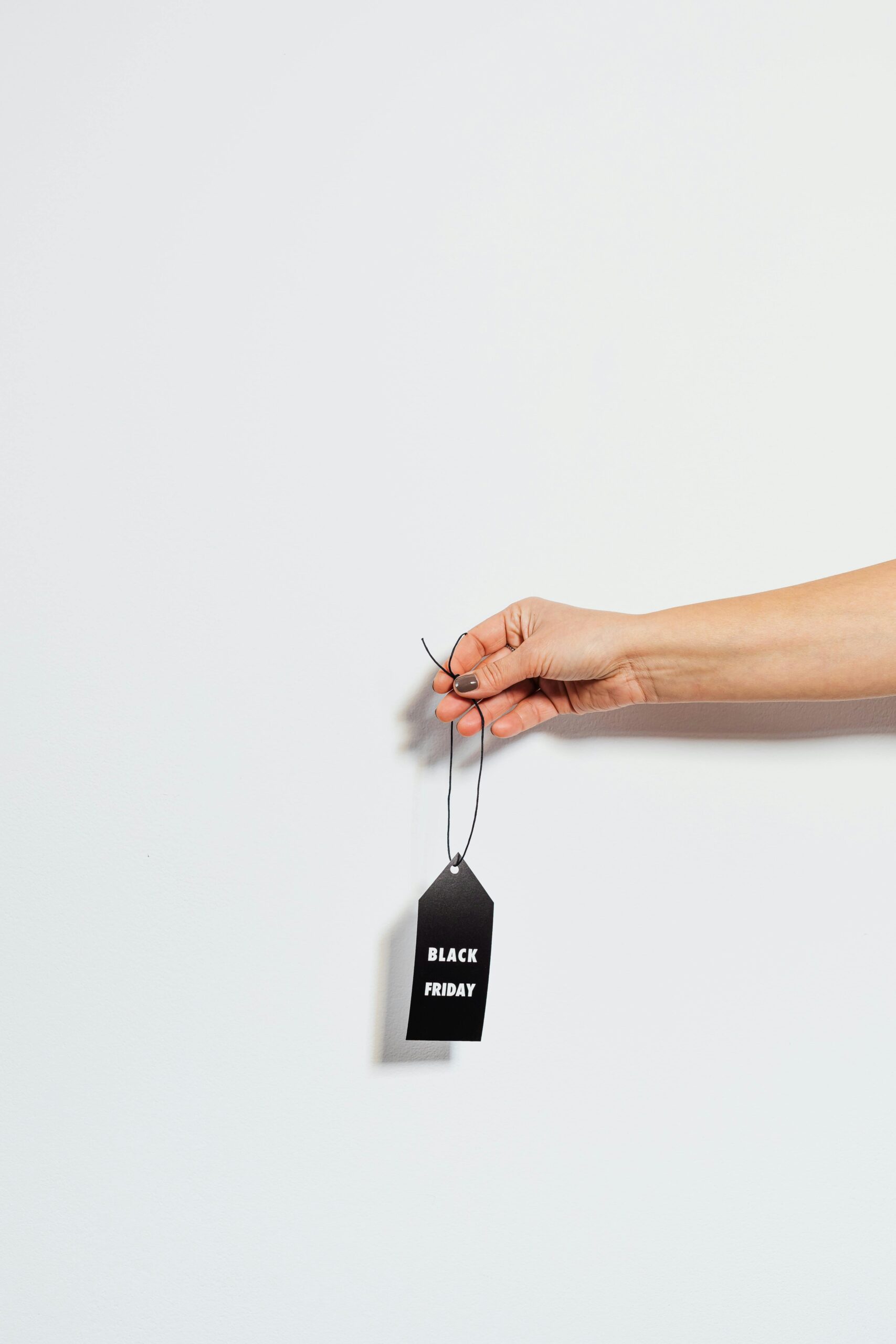 Minimalist image of a hand holding a Black Friday sale tag, ideal for promotions.